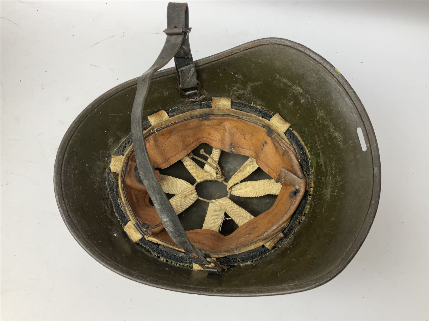 WW2 French M-26 Adrian Pattern Steel Helmet, original olive drab paint finish; flaming grenade badge to the front signifying issue to an Infantry regiment; original leather liner and leather chinstrap; and WW2 Dutch steel helmet with liner and chin strap (2)