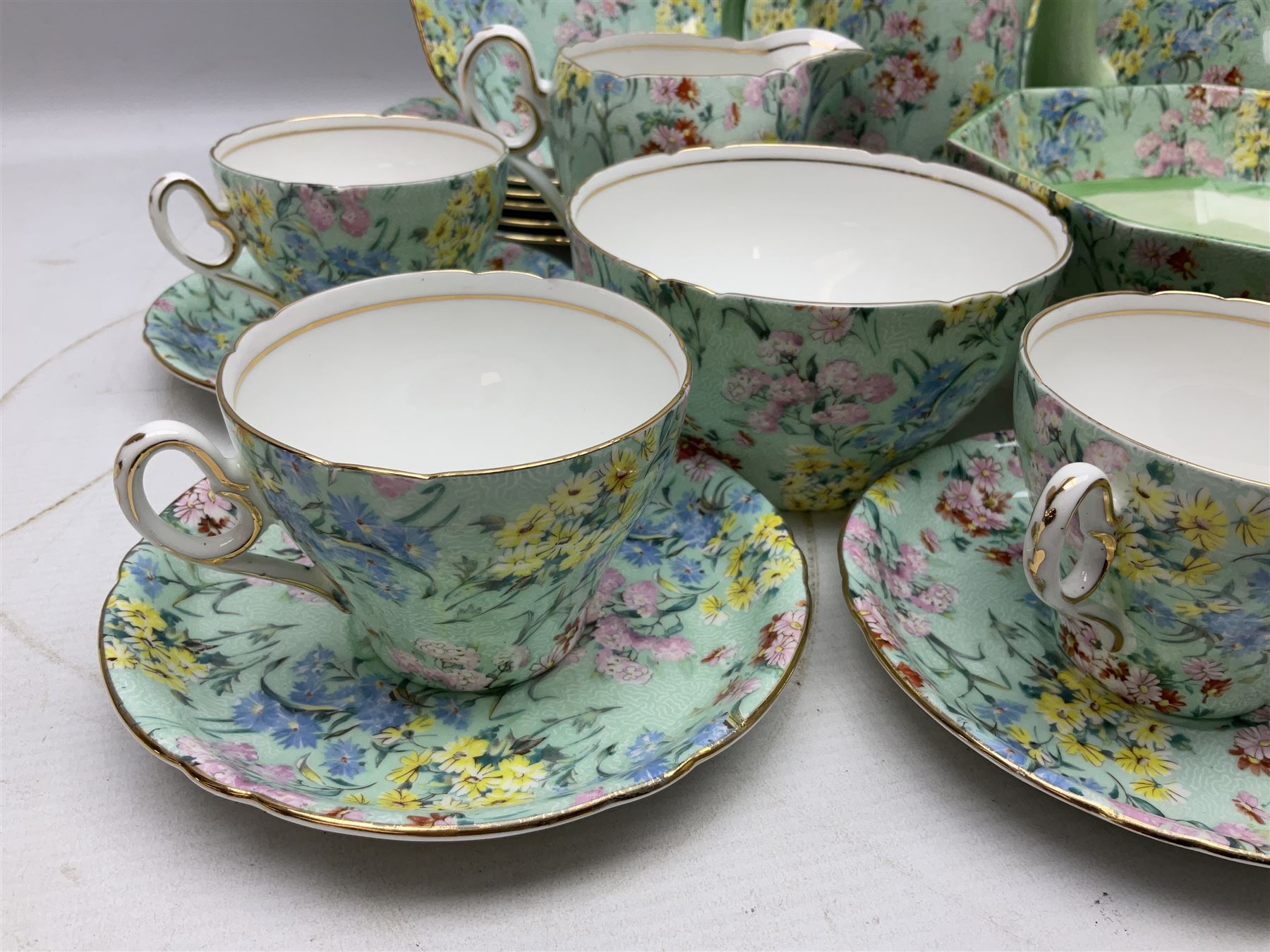 Shelley Melody pattern tea service for six, to include teapot, teapot stand, hot water jug, milk jug, covered sucrier, teacups and saucers, cake plates etc (31)