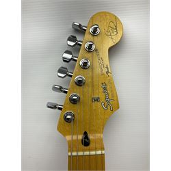 Japanese Squier Fender 'Hank Marvin' Stratocaster electric guitar, c1992, in Fiesta red with tremolo arm and facsimile signature decal; serial no.L037281, L98cm; in hard carrying case.