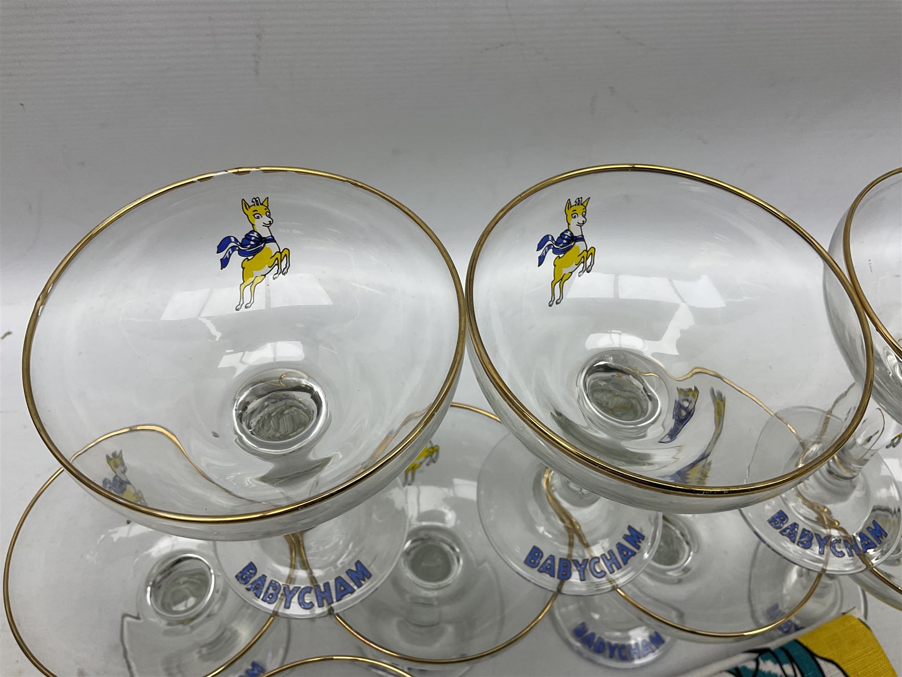 Breweriana; Eight Babycham glasses together with a Babycham plastic fawn mascot and linen I'd Love a Babycham tea towel