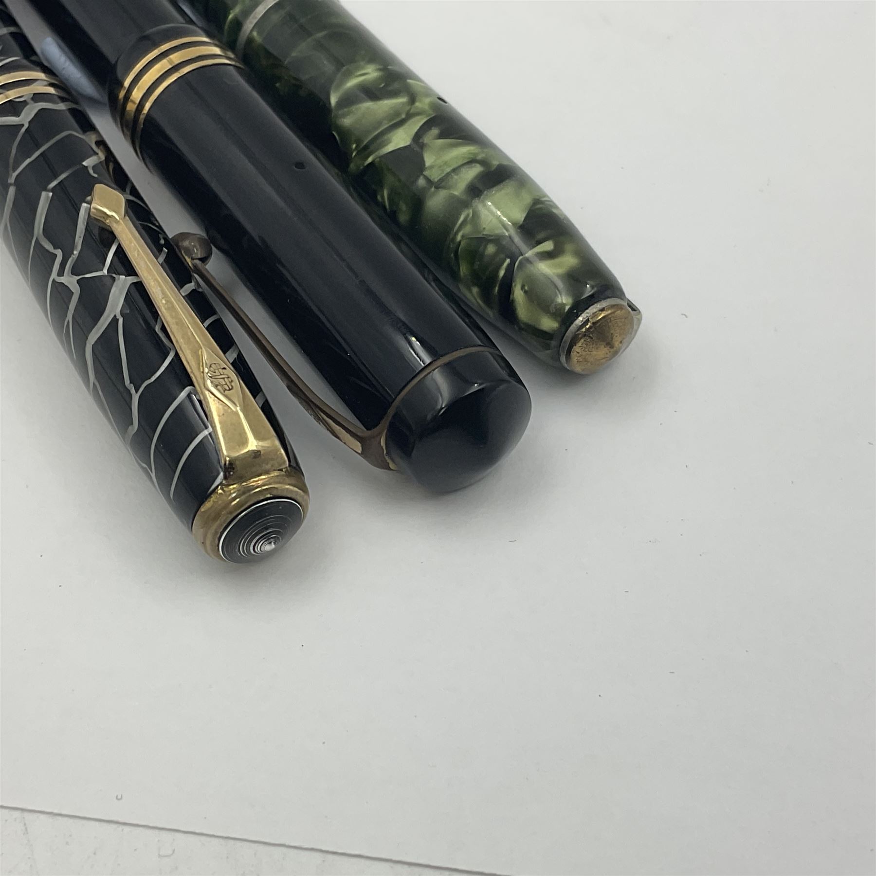 Three Conway Stewart fountain pens, comprising Cracked Ice 28 pen, the black and pearl white barrel engraved Conway Stewart 28 and double banded cap, with gold nib stamped 14ct, together with a Conway Stewart 75 lever fill pen, the green marble barrel and cap with single band and gold nib stamped 14ct and Conway Stewart 55 lever fill fountain pen with black barrel and cap with single broad band and two narrow bands with gold nib stamped Duro 14ct, largest L13cm