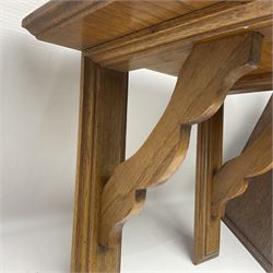 Early 20th century oak smokers cabinet, with brass shield shaped mounts, opening to reveal a compartmentalised interior with three drawers, pipe rack and tobacco jar, together with a small wooden shelf, smokers cabinet H28.5cm
