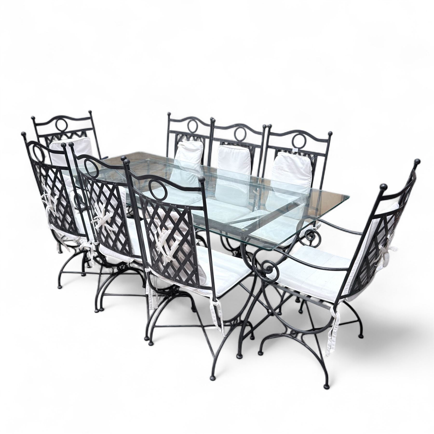Wrought steel rectangular conservatory dining table, with glass top; and six, four side and two armchairs, with lattice backs and X framed bases, loose cushions