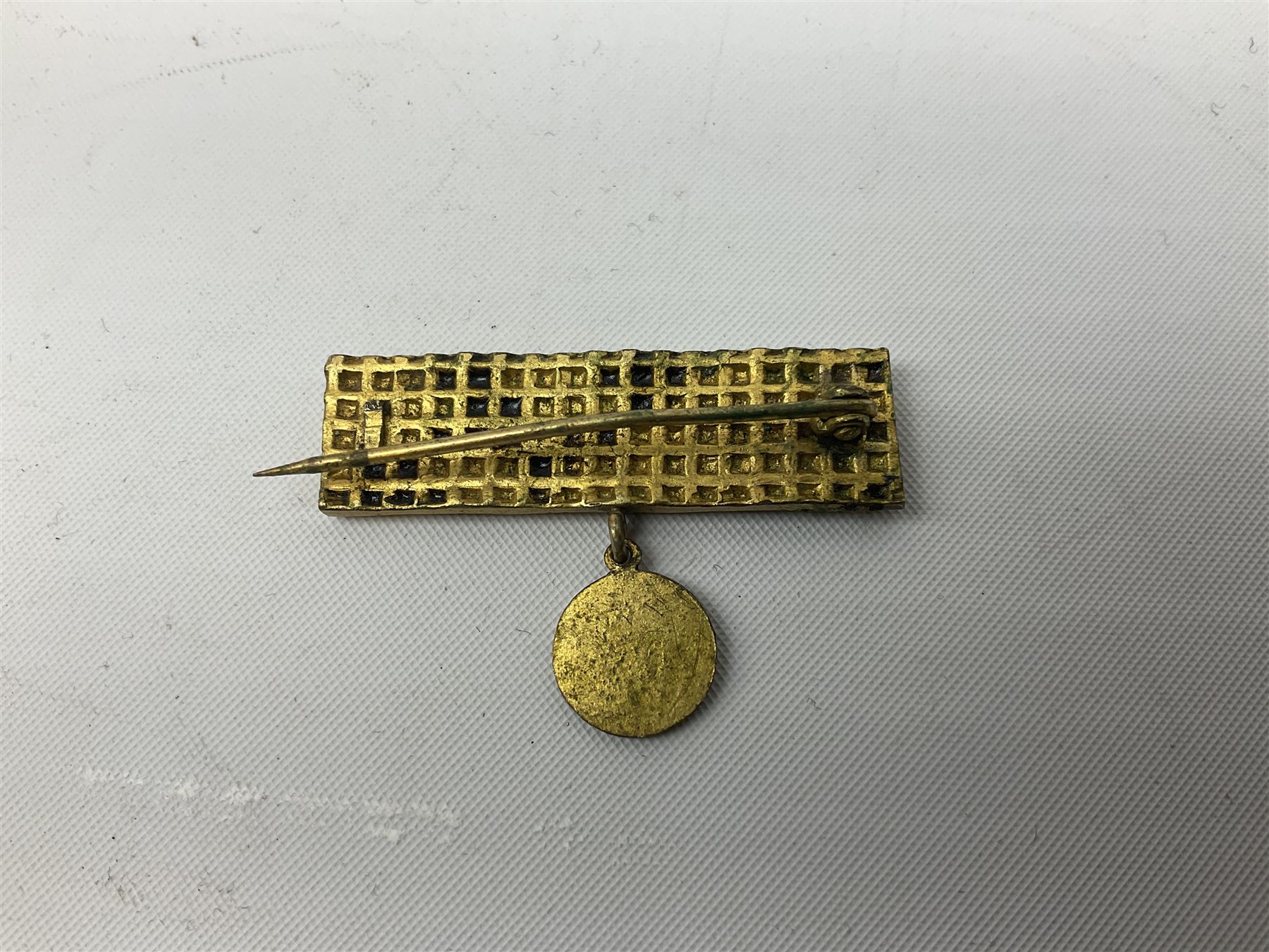 Two WW2 German Army Afrika Korps pith helmet metal side badges; RAD oval metal badge by J.B.u.Co.; WW1 German 1914-1915 bar brooch; and Nienburg War Veteren's Association badge (5)