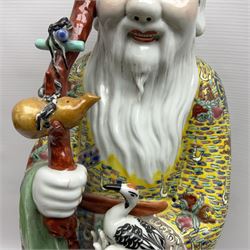 Chinese Republic Period porcelain figure, modelled as Shoulao, wearing elaborately enamelled robes decorated with peaches and flower heads, with impressed mark beneath, H55cm