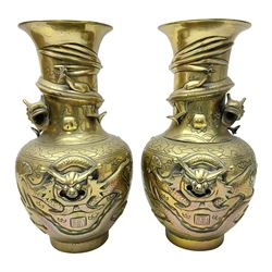 Pair of Chinese brass vases, of ovoid form with elongated neck and fluted rim, decorated in high relief with a dragon chasing a flaming pearl around the neck, the body with dragons, birds and buildings, with character marks beneath, H25cm
