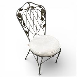 Wrought iron garden dining table with leaf decoration, and set of four matching chairs