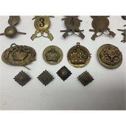Over thirty British and Continental military metal badges; together with quantity of shoulder titles, collar dogs, rank pips, uniform buttons etc