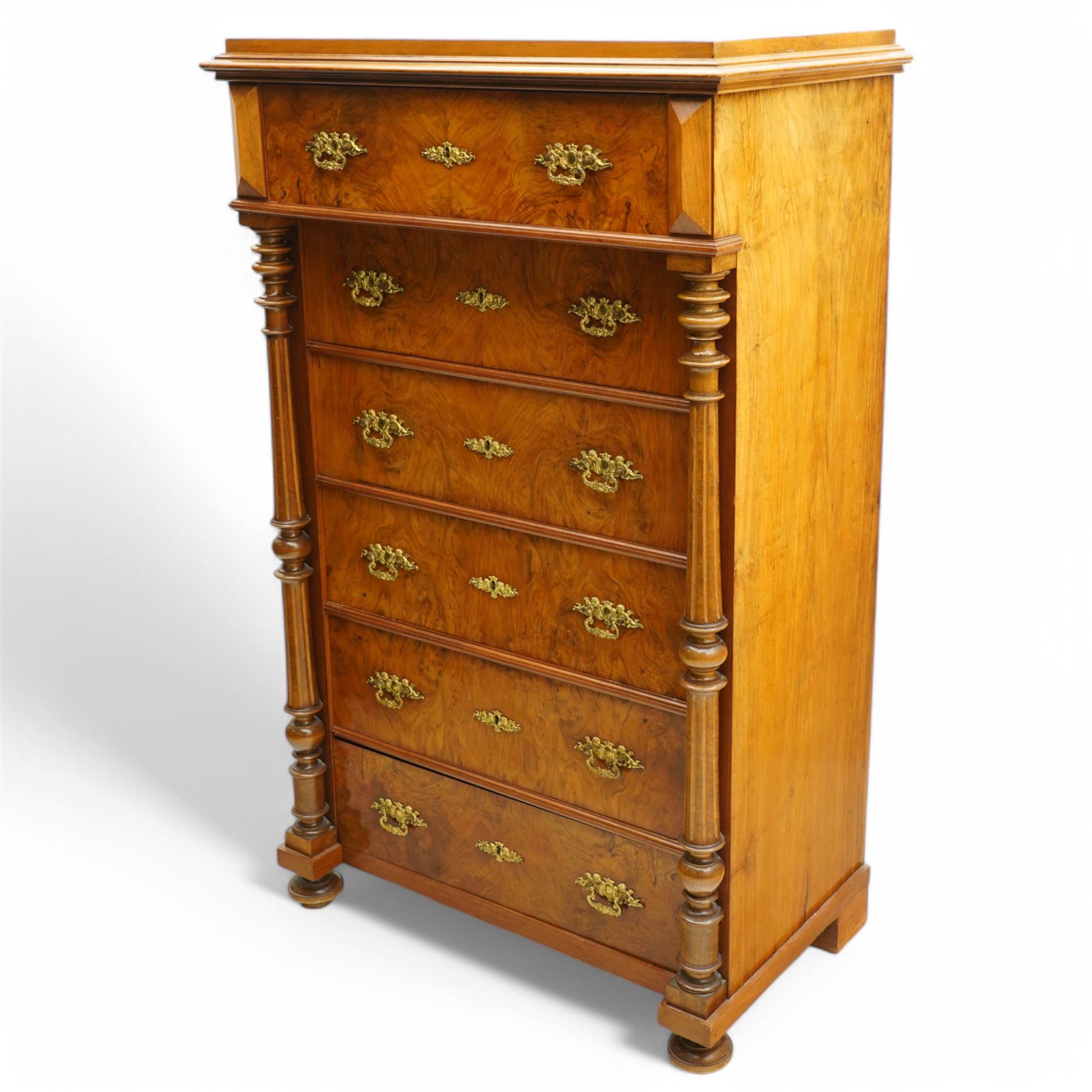 Tall late 19th century walnut chest, stepped and moulded top over six drawers, ornate cast gilt metal handles, enclosed by turned and fluted upright columns, on turned front feet 