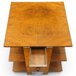 Art Deco walnut coffee table, square book-matched veneered top over single frieze drawer with brass handle, flanked by open side shelves, raised on rectangular end supports