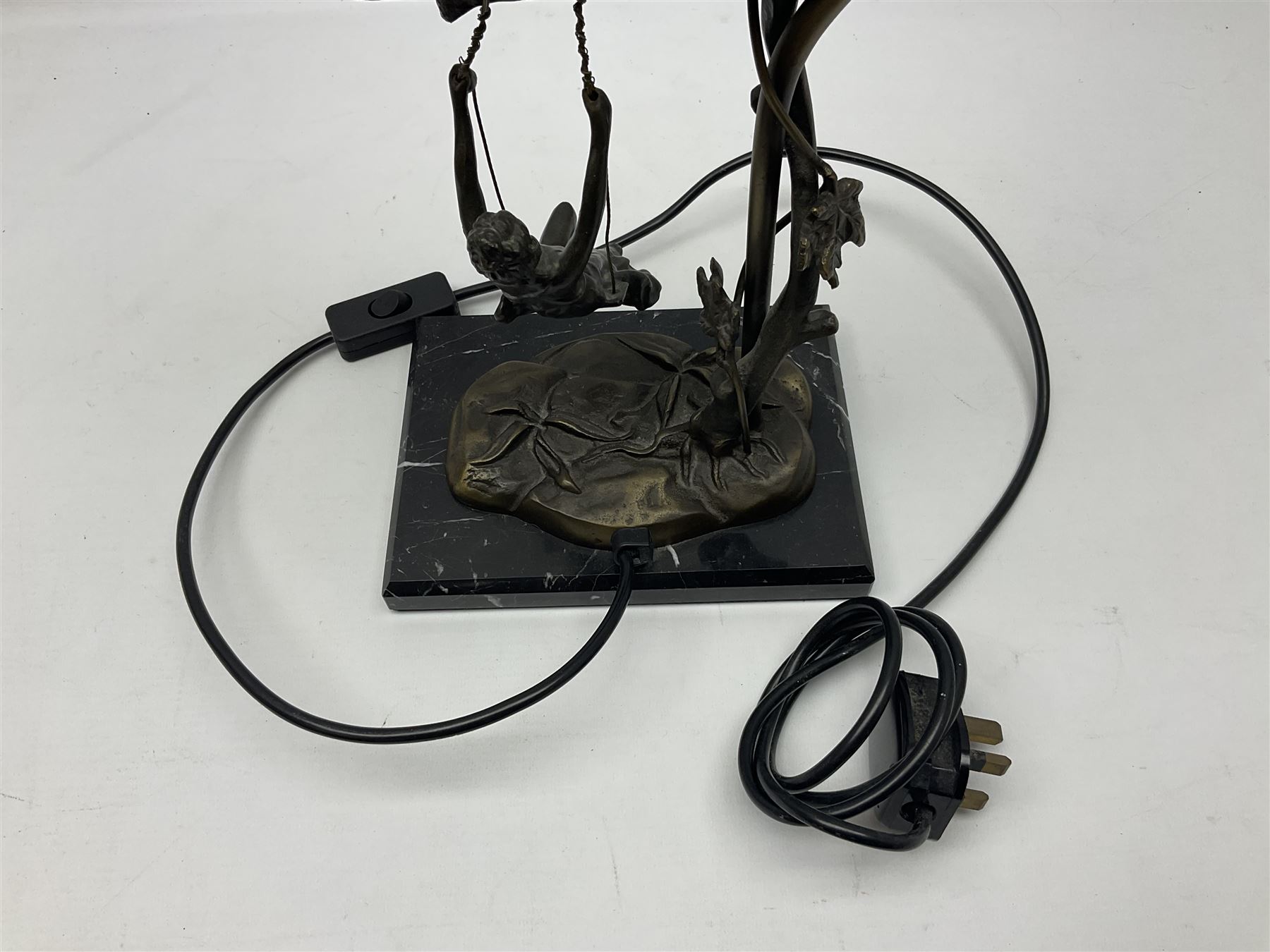 Art Nouveau style lamp in the form of a woman on a swing, with a green mottled shade, upon a marble base H52cm