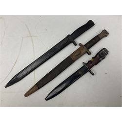 British No 7 MKI knife bayonet with 20cm single edged fullered clipped point blade;  blackened steel, large muzzle ring cross-guard; blackened swivelling pommel marked 'F5H'; red Tufnol composite grips; in blackened steel scabbard L33cm overall; British Pattern 1888 bayonet with scabbard; and German Ersatz bayonet with scabbard (3)