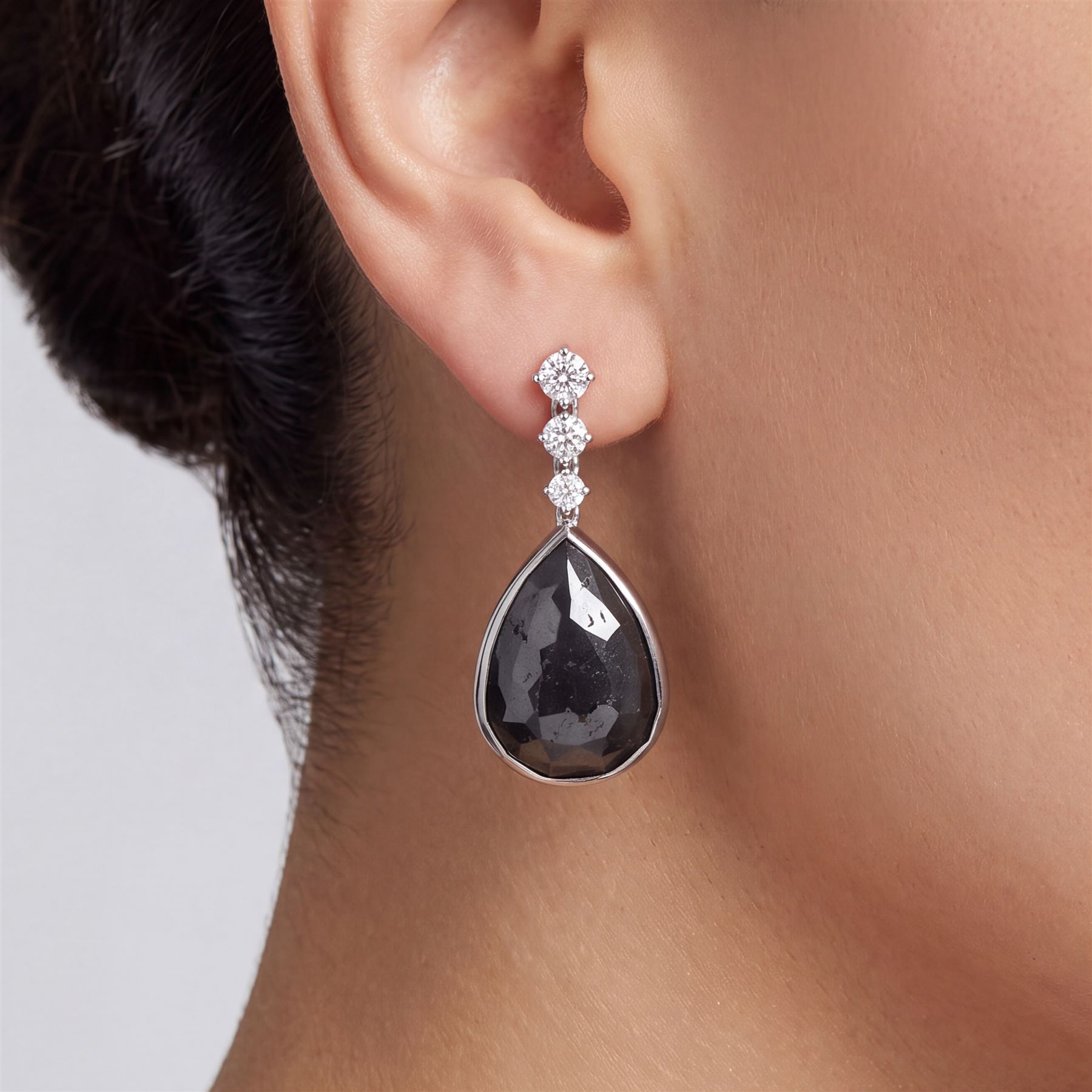 Pair of 18ct white gold black and white diamond pendant stud earrings, three graduating round brilliant cut diamonds suspending a single pear cut black diamond, hallmarked, total white diamond weight approx 1.05 carat, total black diamond weight approx 43.65 carat 