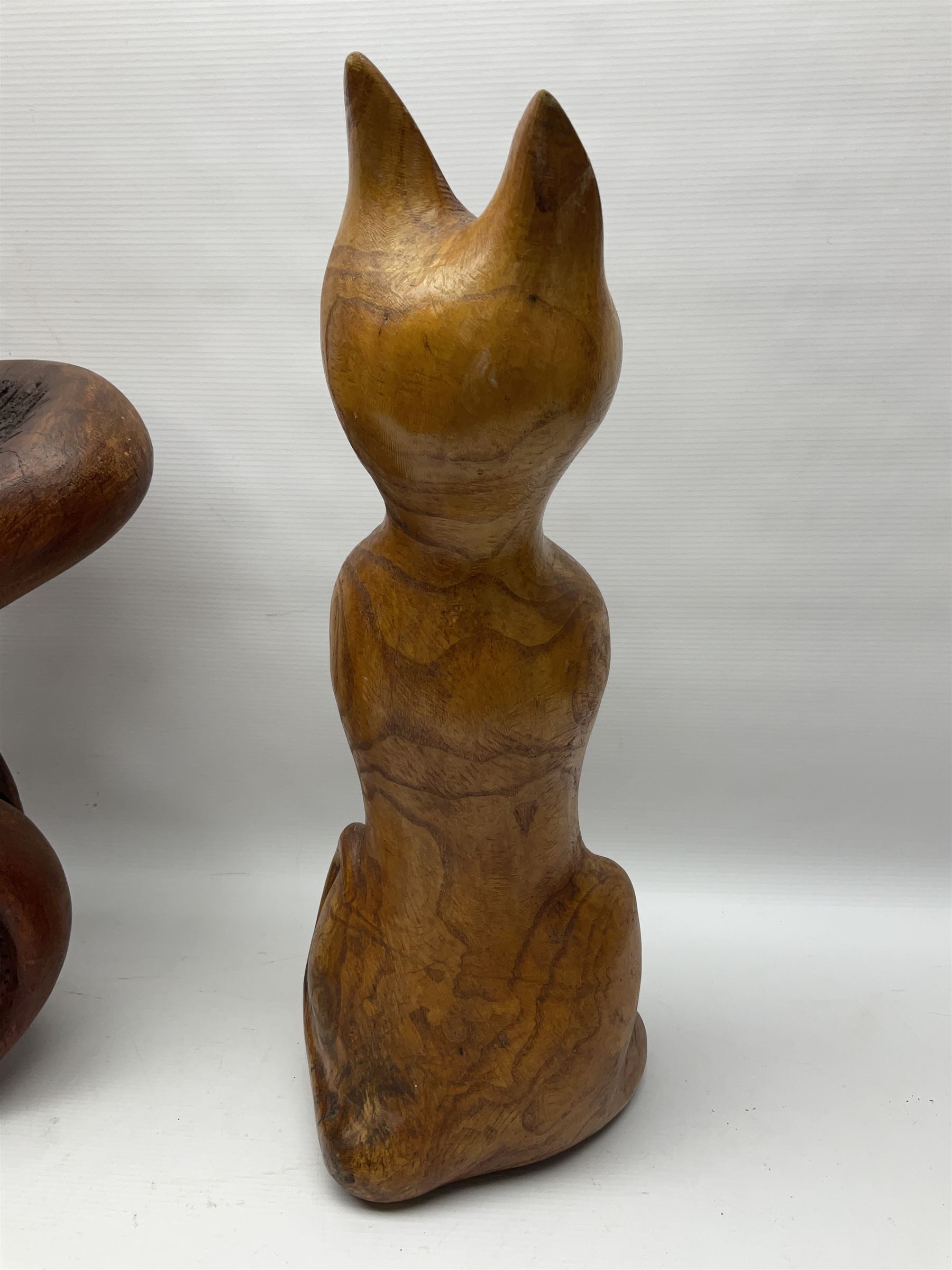 Helen Skelton (British 1933 – 2023): Three carved wooden abstract sculptures, each modelled as a cat, with carved or painted features, largest H63cm. Born into an RAF family in 1933 in Kent and travelled the world extensively during her childhood. After settling in Bridlington, Helen immersed herself in painting, textiles, and wood sculpture, often inspired by nature's beauty. Her talent was showcased in a one-woman show at Sewerby Hall and recognised with the sculpture prize at Ferens Art Gallery in 2000. Sadly, Helen’s daughter passed away from cancer in 2005. This loss inspired Helen to donate her sculptures to Marie Curie upon her passing in 2023.