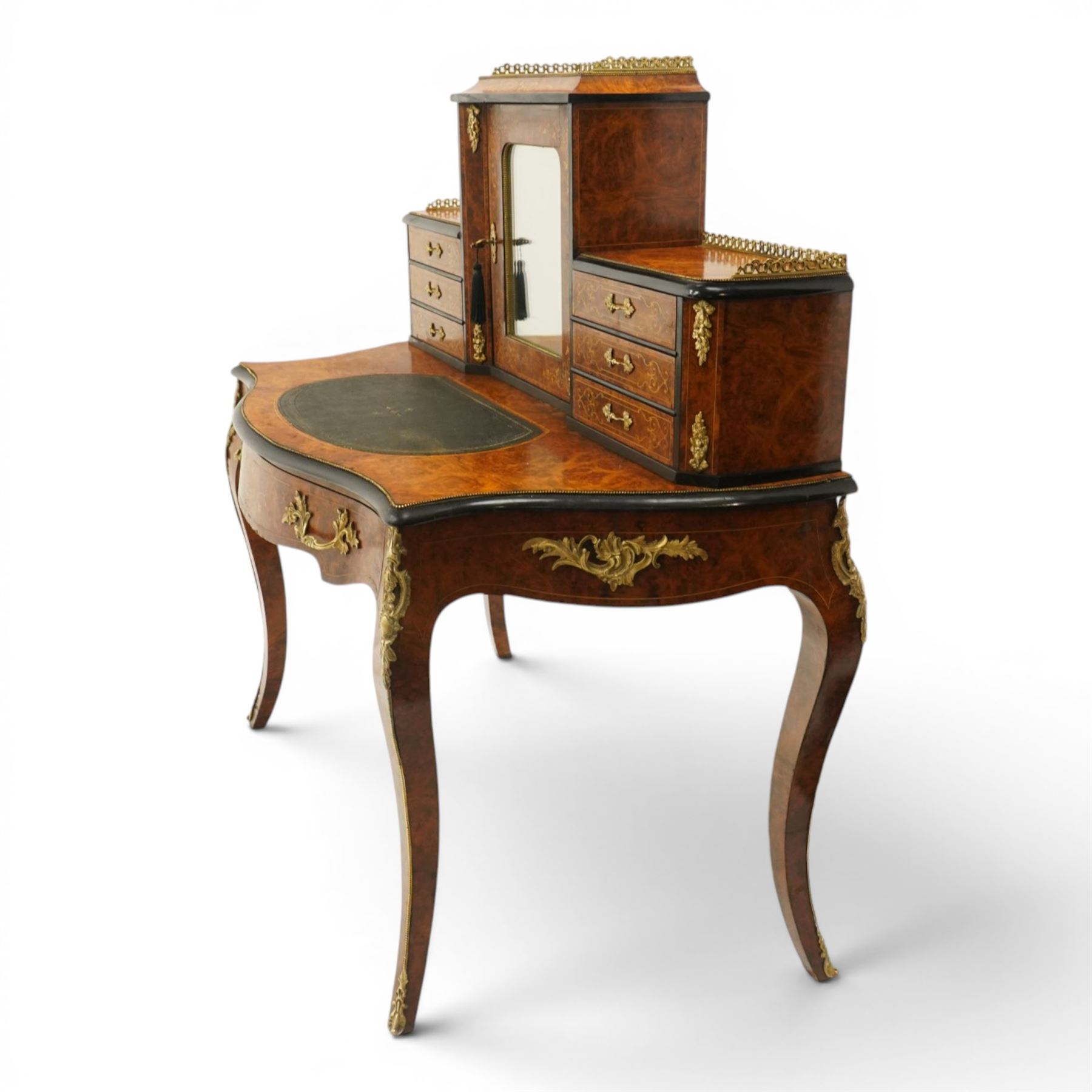 19th century French inlaid figured walnut and ebonised Bonheur de Jour or writing desk, the raised upper section with pierced brass three-quarter gallery, over a mirror glazed cupboard and a combination of drawers, the shaped and moulded top with leather inset and satinwood stringing, with brass beading too the ebonised edge, fitted with a serpentine fronted frieze drawer, raised on cabriole supports, inlaid throughout with scrolling foliate decoration in boxwood and ornate cast brass mounts and handles