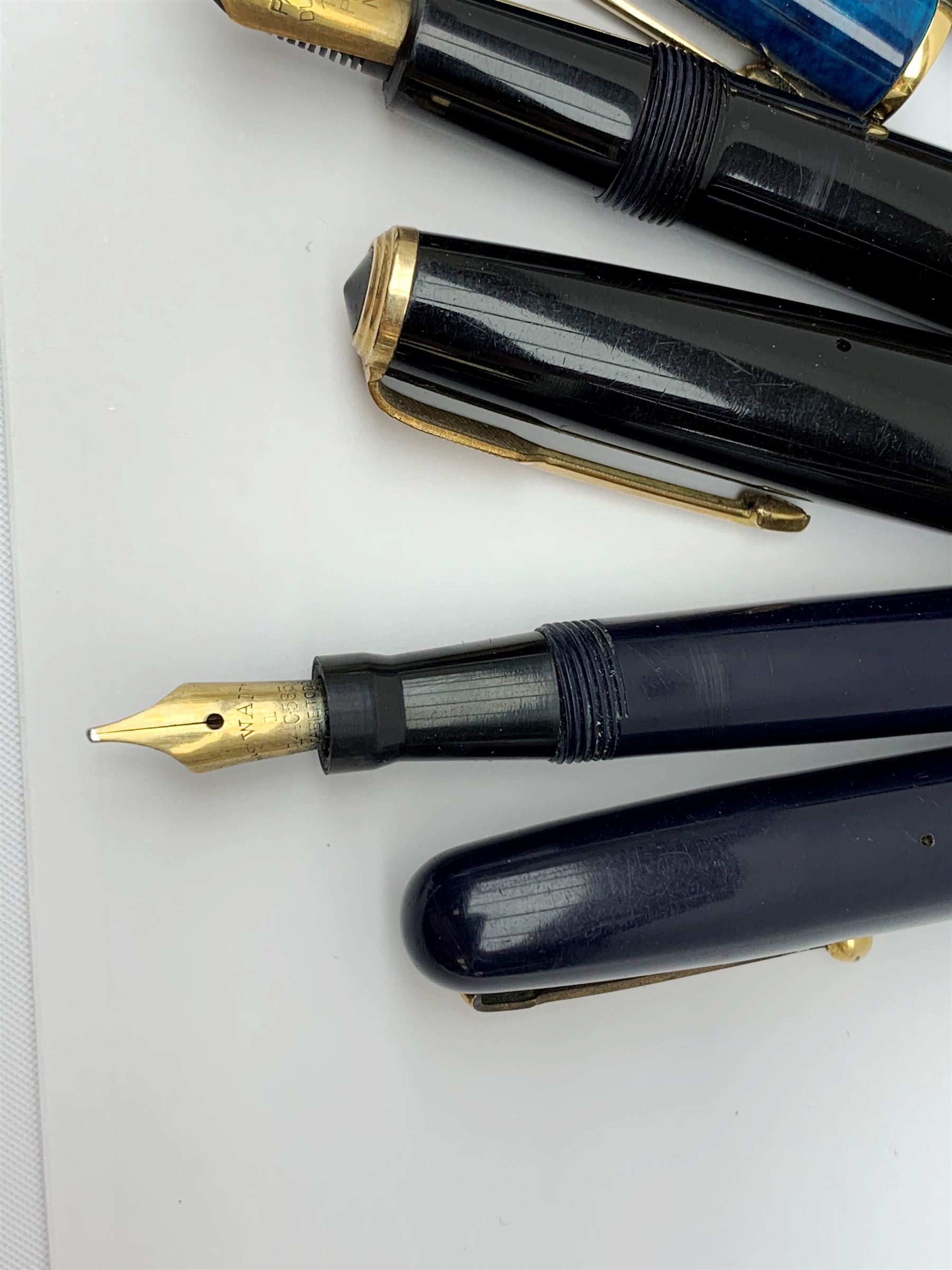 A group of four fountain pens, comprising Parker Duofold, nib marked 14K, Swan Mabbie Todd & Co Ltd Self Filler, nib marked 14C 585, Conway 57, nib marked 14ct, and Waterman Laureat. 