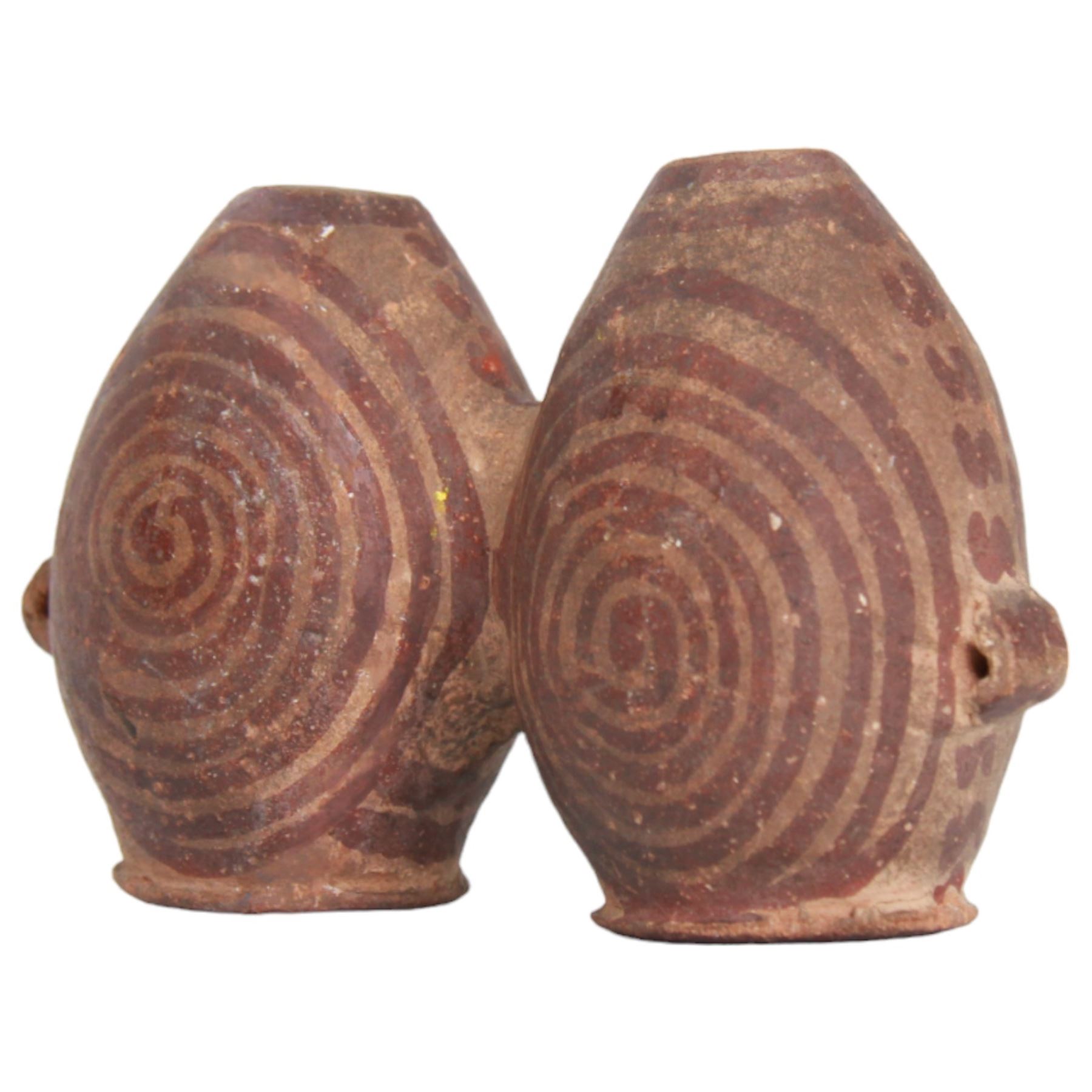 Miniature Egyptian pottery double-bodied jar, Predynastic Period, the two conjoined jars of ovoid form, each with pierced lug handle, and painted with spirals, tapering to flat bases, bearing Sotheby's label, H6cm W10cm
