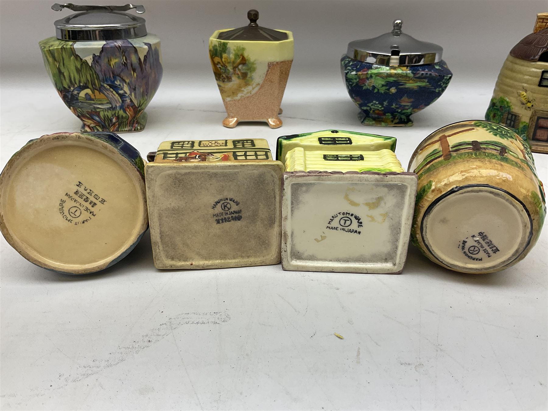 Collection of Japanese Maruhon ware novelty preserve pots, to include examples modelled as a windmill and cottages, together with other 1920s and 30s Art Deco style preserve pots, etc