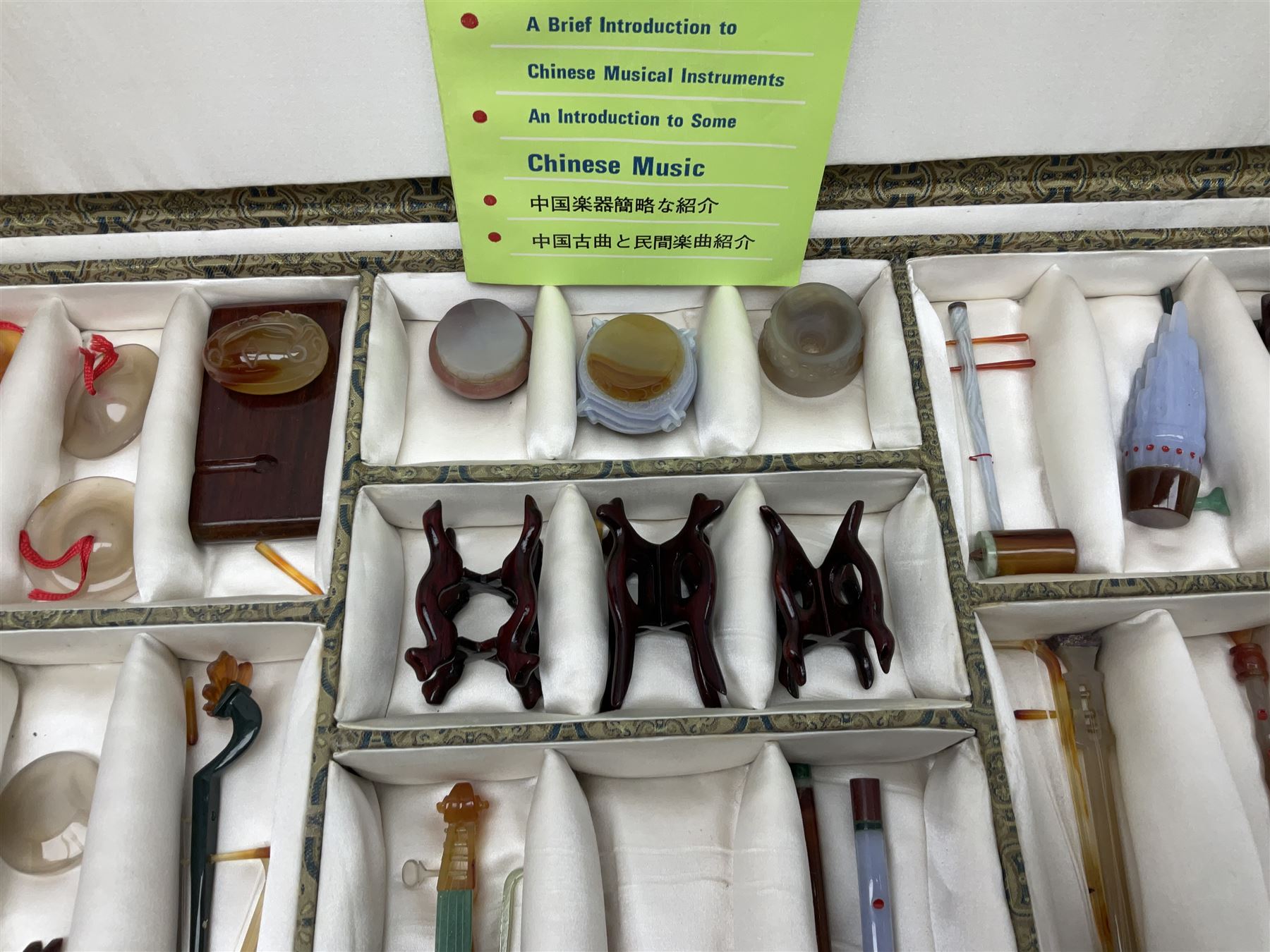 Chinese boxed collection of miniature polished hardstone musical instruments with hardwood stands
