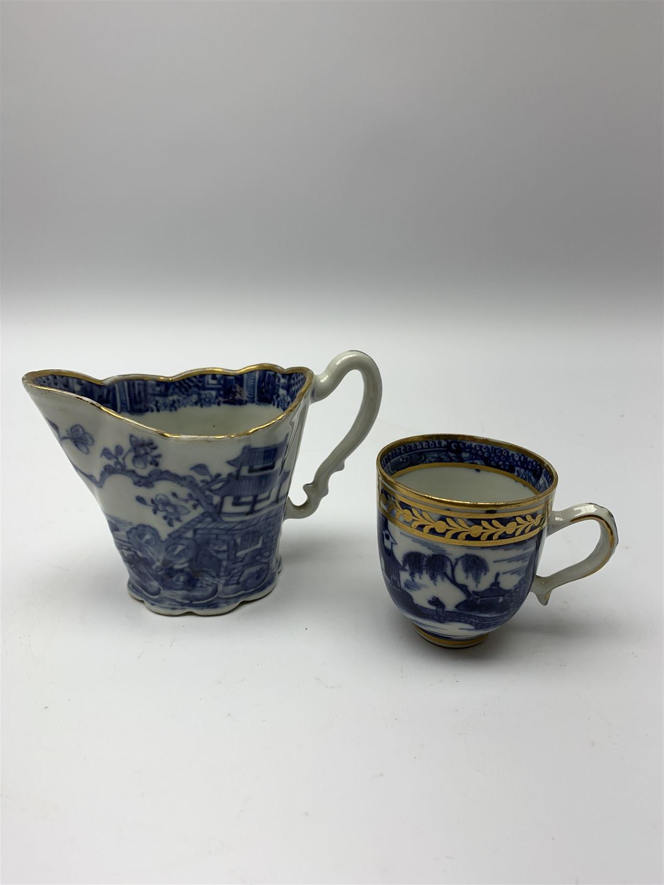 18th century Chinese blue and white porcelain plate, of octagonal form decorated with a riverside scene with pagodas, fence, and trees, within lattice and key fret detailed border, D22.5cm, together with a late 18th/early 19th century blue and white cream boat of English shape, H8.5cm, and an early 19th century Chinese blue and white coffee cup, H6cm, both decorated in riverside scenes 