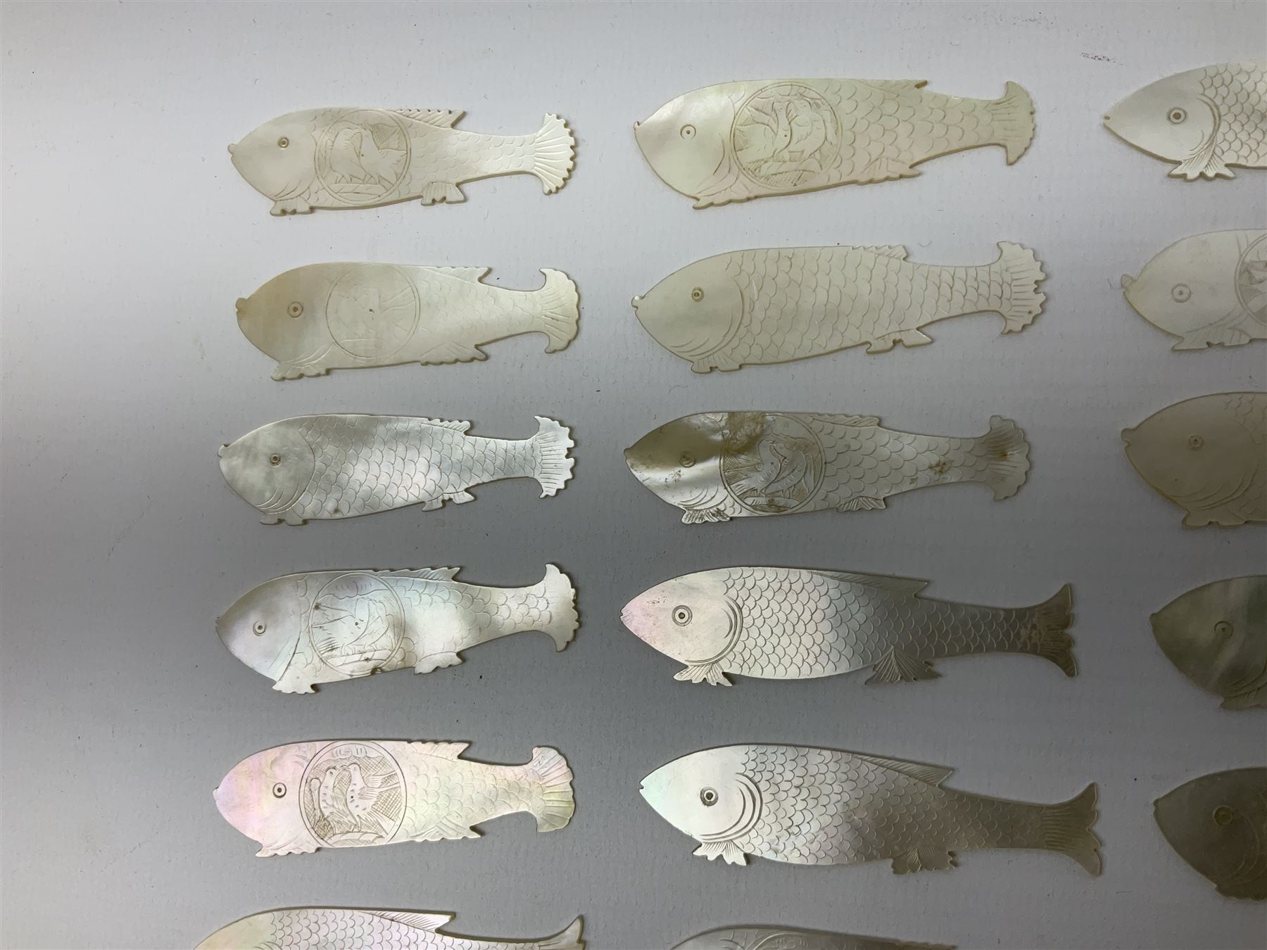 Collection of fifty two Chinese mother of pearl gaming counters or tokens, of various size and form including rectangular, circular and fish shaped examples, various decoration including floral motifs, largest rectangular examples L4cm