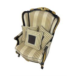 Thomas Messel - Georgian style ebonised and gilt wingback armchair, upholstered in striped fabric, on cabriole front feet