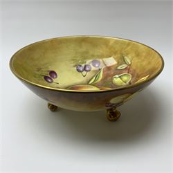 A Coalport bowl hand painted to the interior and exterior with fruit still life upon a mossy ground, signed N Lear, upon three scrolling gilt feet, D26.5cm. 