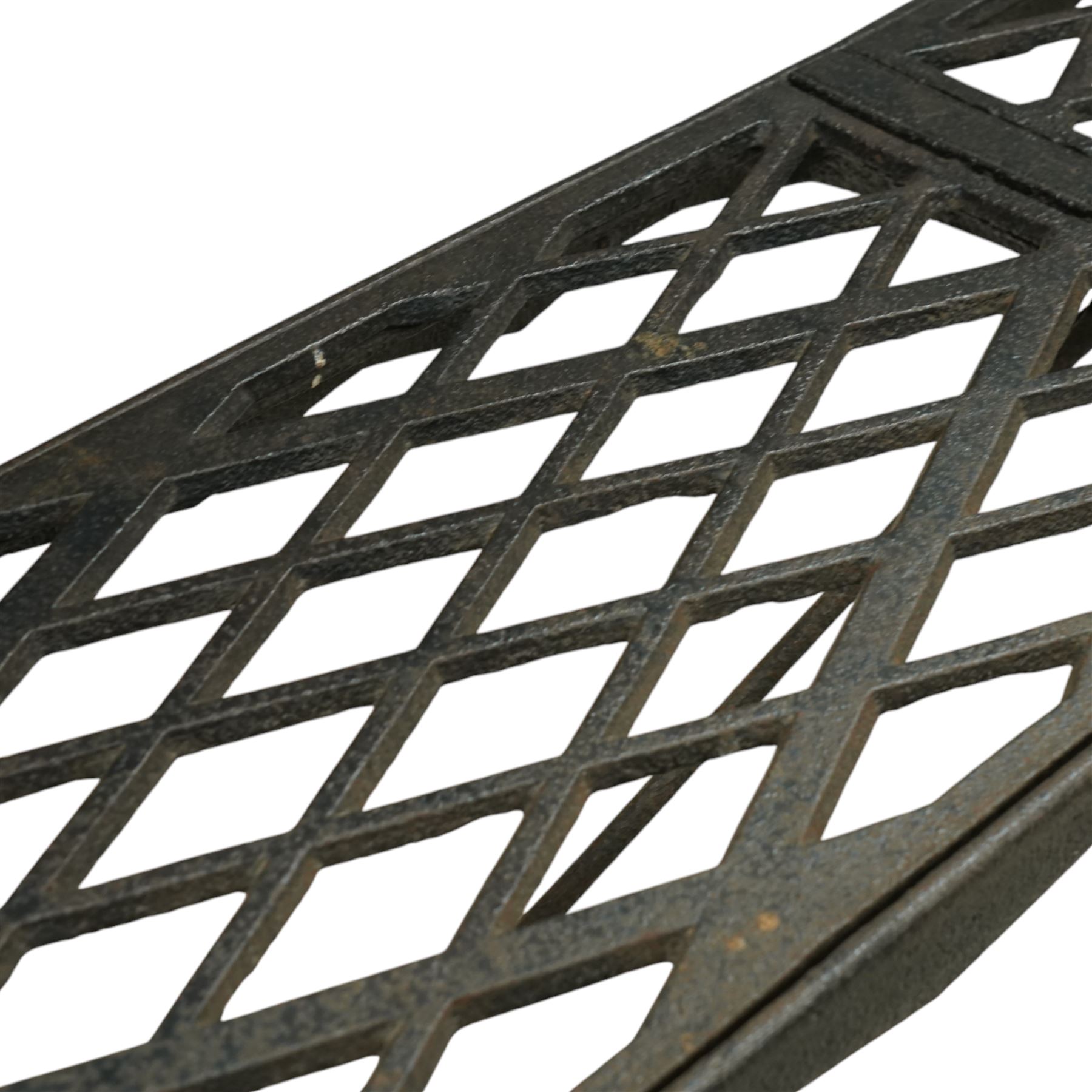 Two cast iron garden benches, rectangular seat with lozenge grate panels, on X-framed supports 