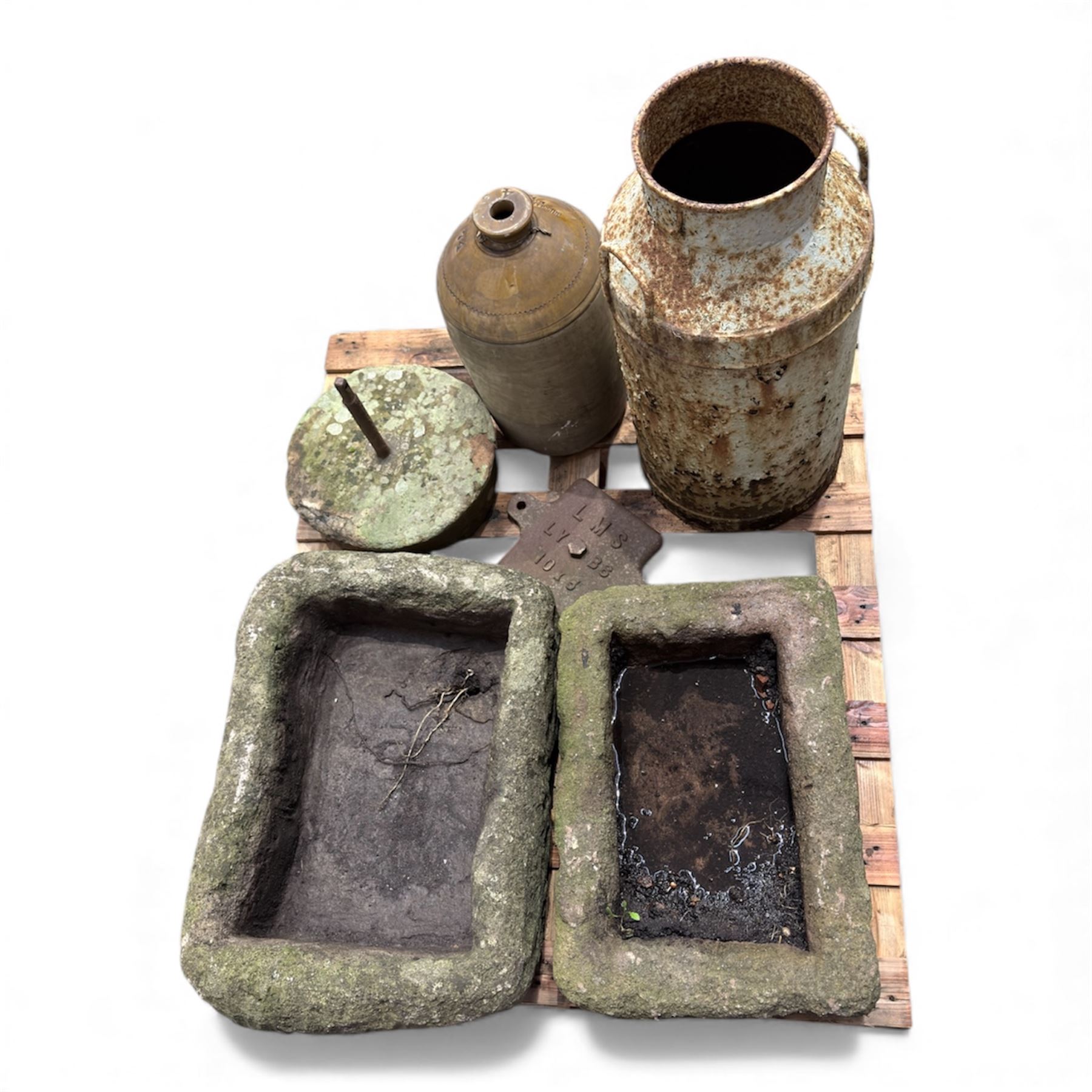 Two 19th century stone troughs, with mill stone, flagon and metal milk churn 