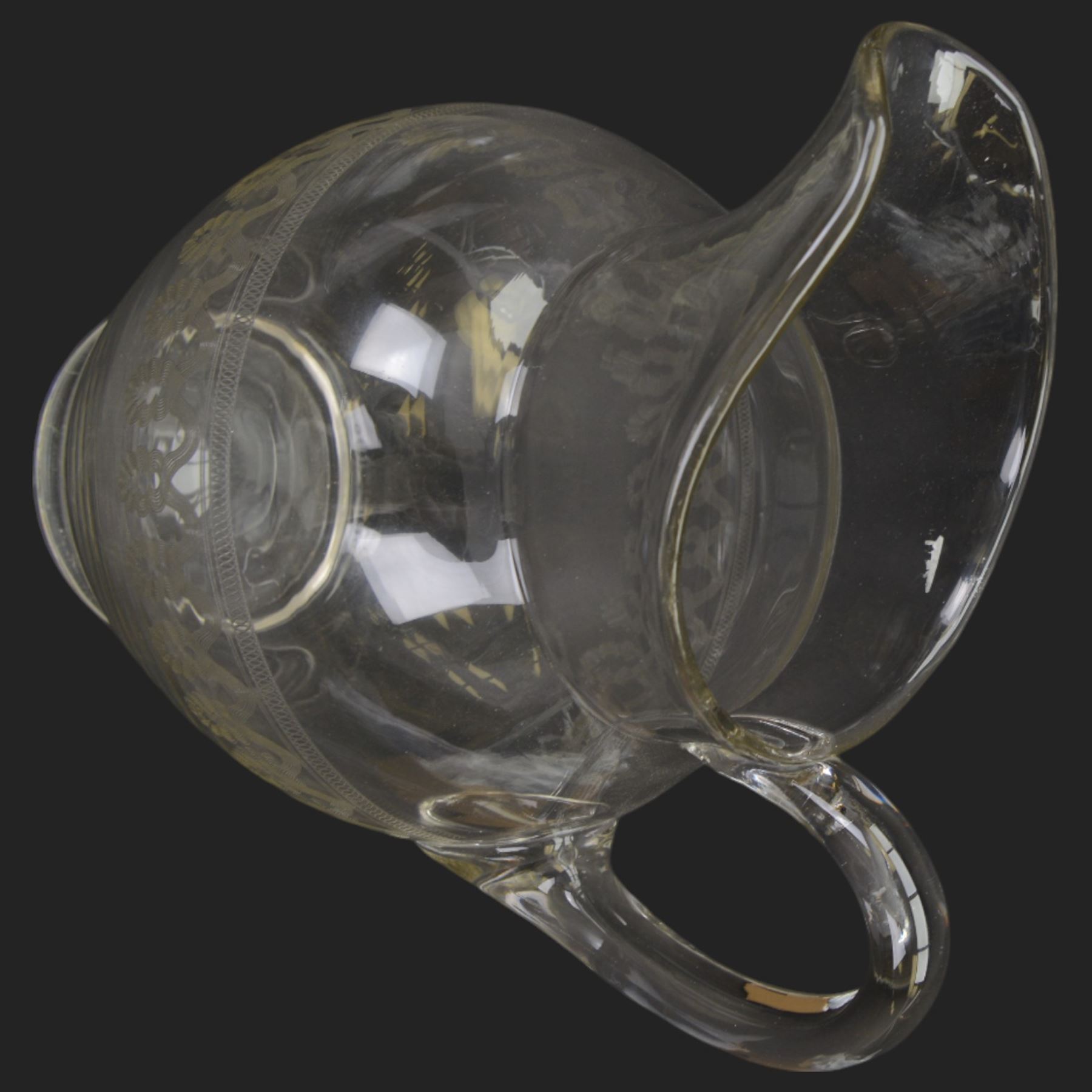 Edwardian glass wash jug and bowl, each engraved with looping border, jug H31.5cm, bowl D39.5cm