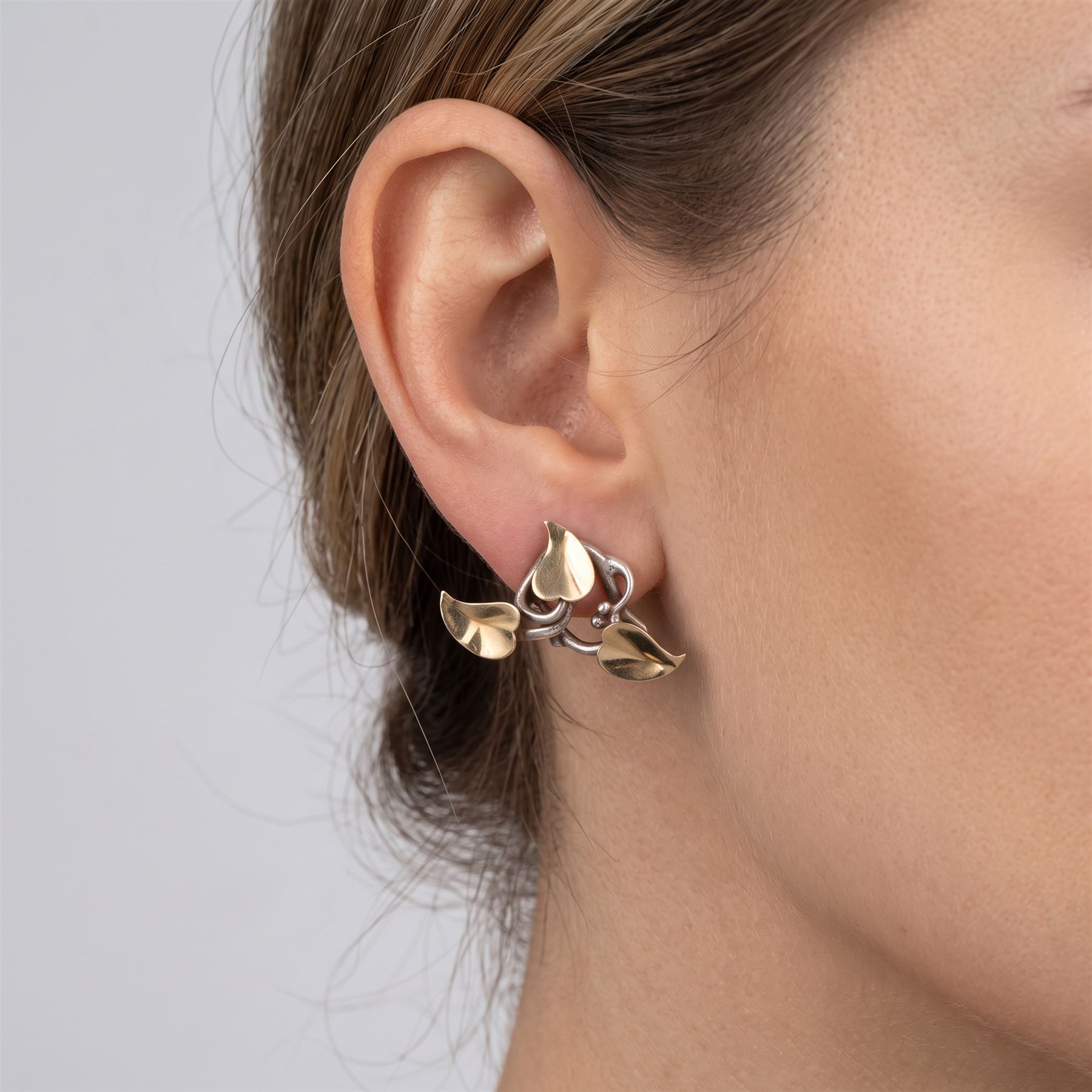 Brett Payne pair of silver and 9ct gold fruiting vine earrings, each stud with twisted silver vine and 9ct gold leaves, Sheffield 1998