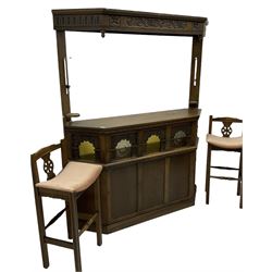 Old Charm - oak corner bar, the canopy frieze carved with scrolls, front decorated with arched apertures glazed with bullseye and mottled glass panes, skirted base, together with two bar stools