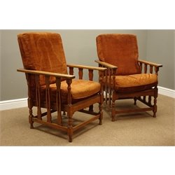  Pair Arts and Crafts period oak reclining armchairs, with pierced shaped arm supports, upholstered loose cushions   