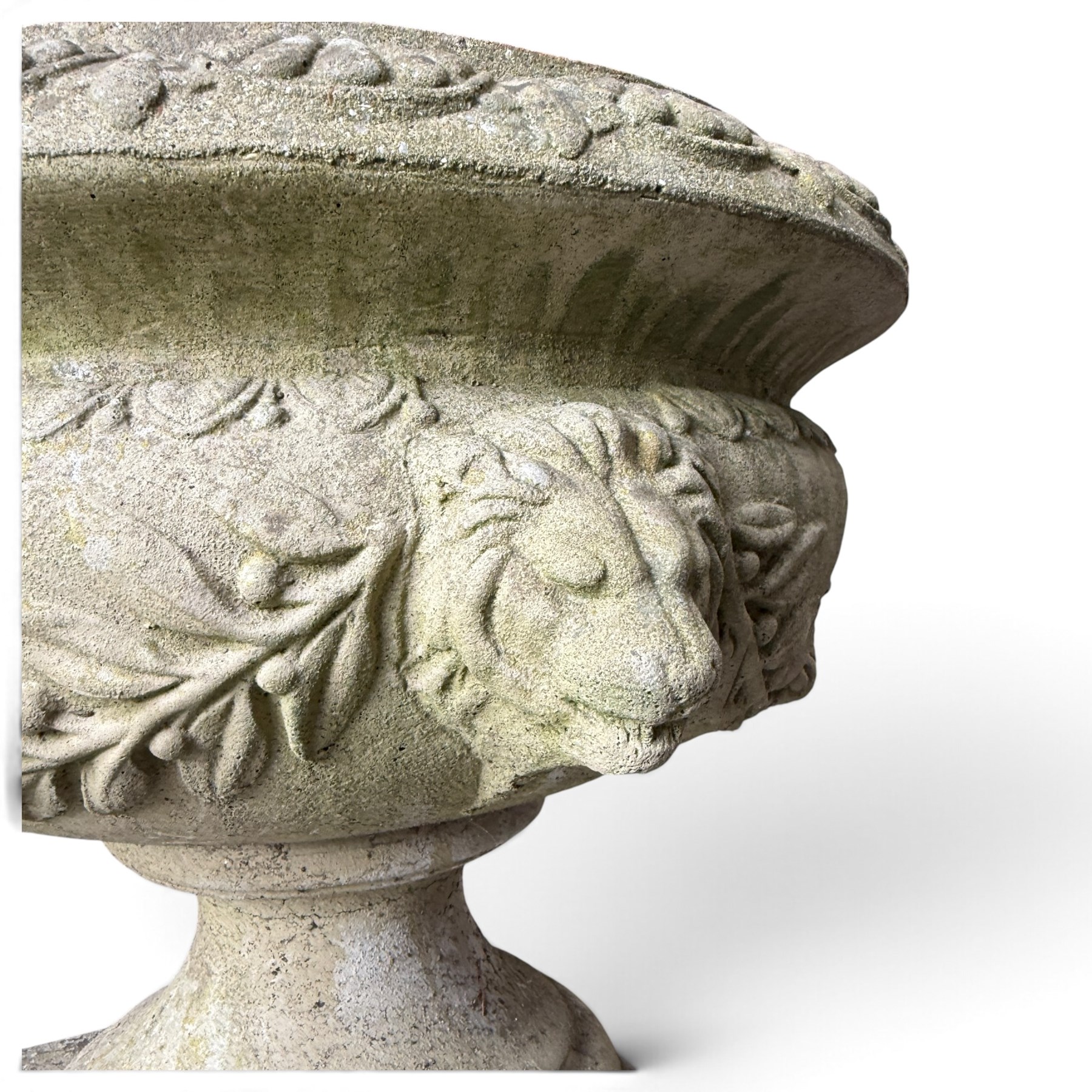 Regency design weathered cast stone garden urn of kylix form, the anthemion and arrowhead moulded everted rim over a fruiting laurel and lion-mask relief decorated body, waisted socle on square base, stamped HGC