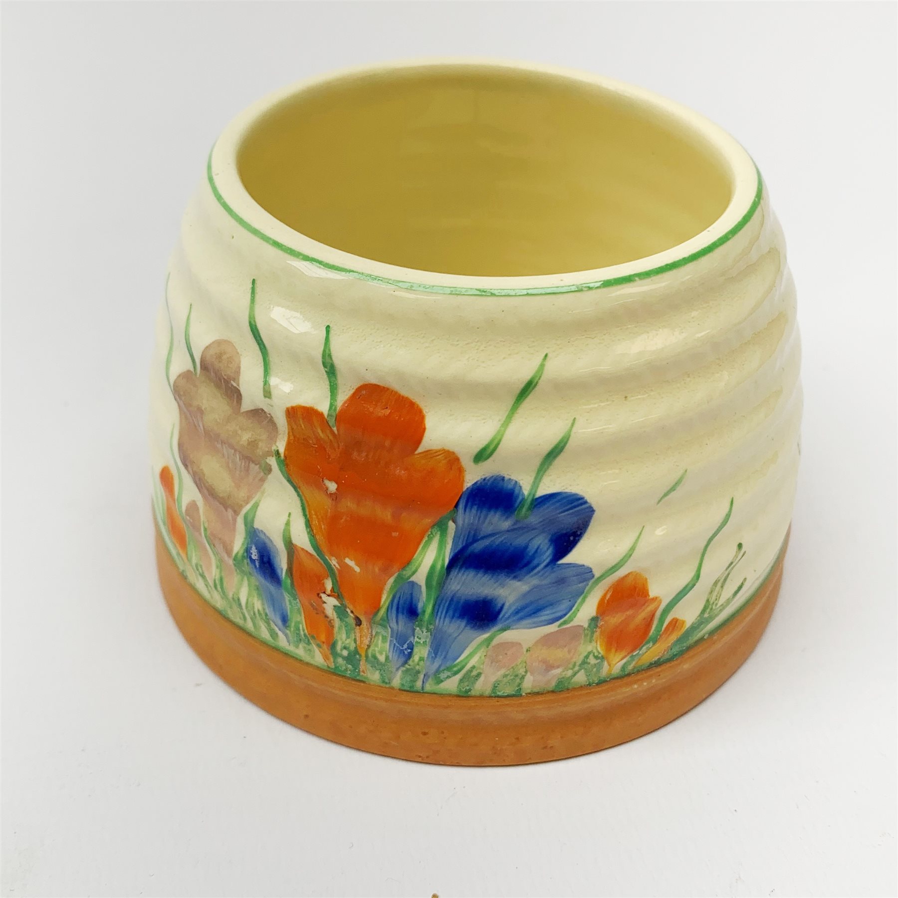 A Clarice Cliff Newport Pottery honey pot, modelled in the form of a beehive and decorated in the Crocus pattern, H10cm.