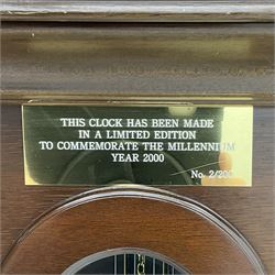 A  20th century longcase clock made to celebrate the millennium in the year 2000, this clock being No 2 of only 200 manufactured by  Richard Broad in Bodmin Cornwall, with a mahogany effect case and traditional swans neck pediment with three brass finials, break arch hood door on a trunk with recessed columns and full length glazed door, on a square plinth with inlay and a shaped base, brass dial with brass spandrels, silvered chapter ring, seconds dial and working moon phase to the arch, weight driven three train movement striking the quarters and hours on 12 gong rods, with a choice of St Michael, Westminster and Wittington chimes, with chime selector and chime/silent facility. With three brass cased weights and gridiron pendulum.





