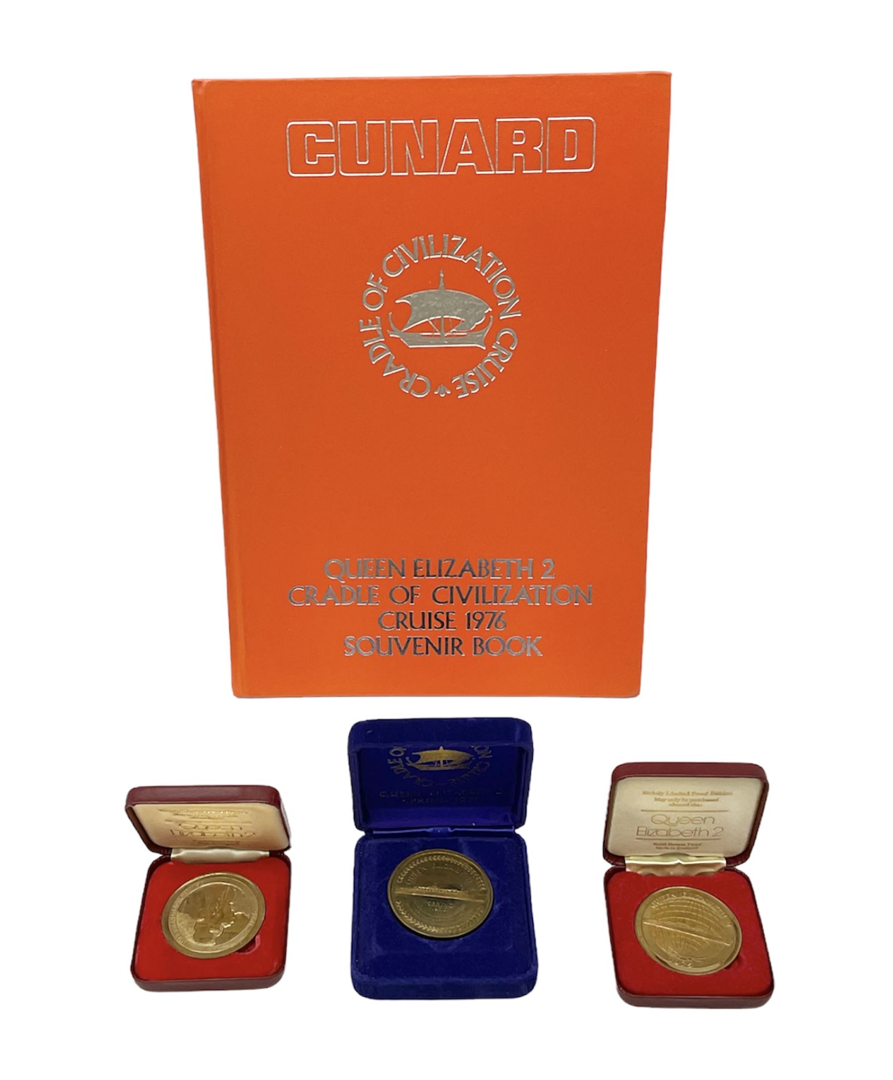 Queen Elizabeth II cradle of civilization cruise 1976 bronze medallion with related book and two other Queen Elizabeth II commemorative medallions for cruises in 1975 and 1976, all cased