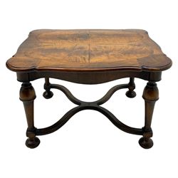 Figured mahogany coffee table, shaped moulded top with oval book-matched veneered panels, on turned supports united by waved X-shaped stretchers 