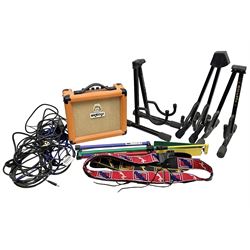 Three folding tubular guitar stands marked TGI and Giraffe; Orange Crush 10 guitar amplifier; Kinsman multi-coloured adjustable metal music stand; two guitar straps marked Fender; and quantity of cables