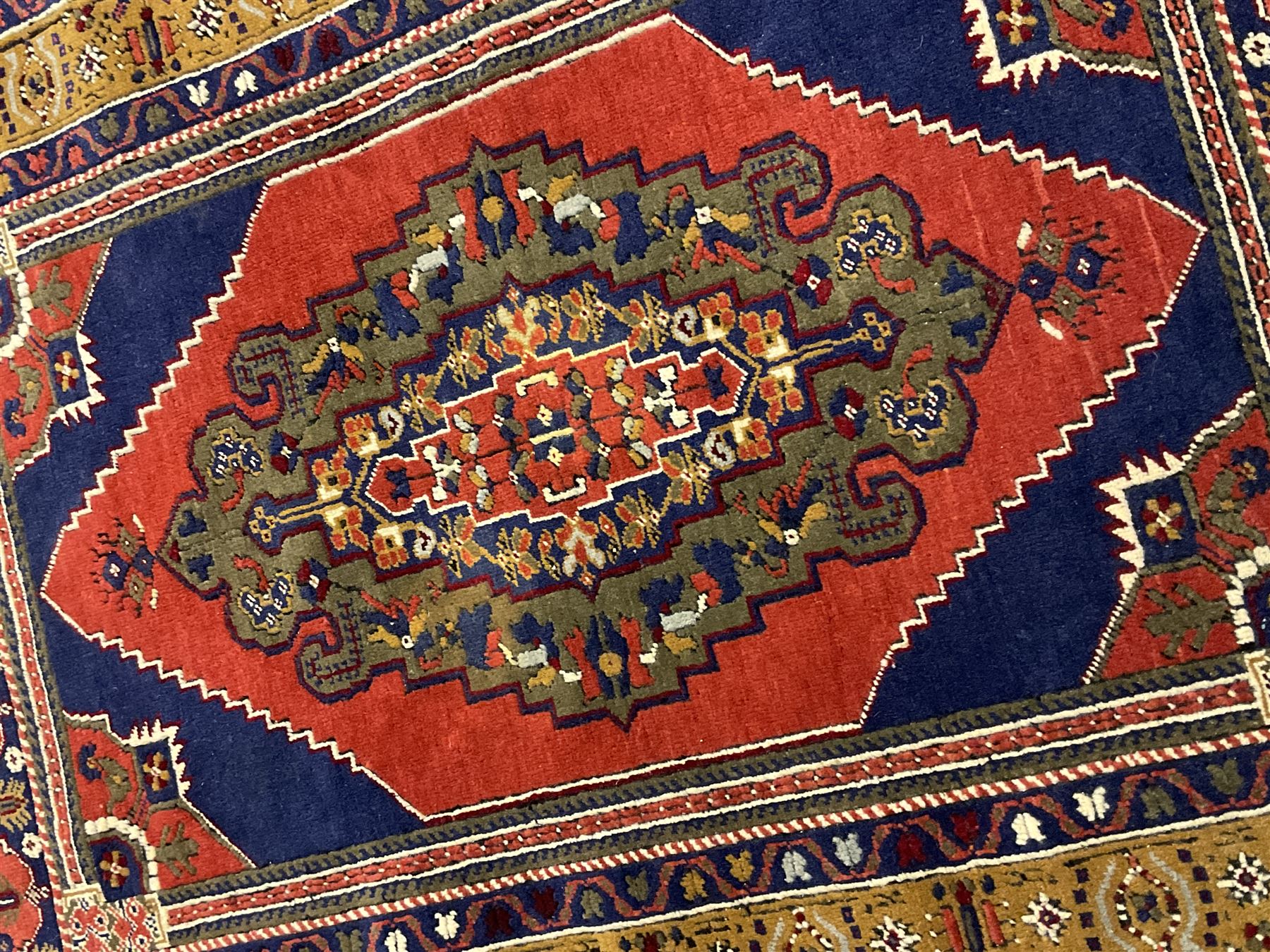 Turkish Taspinar rug, blue ground with central lozenge and medallion, the outer borders decorated with stylised motifs