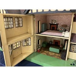 Large Tri-ang No.93 doll`s house in the 'Stockbroker's Range' c1935; two-storey double-fronted Tudor design, half timbered gables, two-storey bay windows, cream and mock shrubbery to front, opening metal framed windows with green shutters, red simulated tiled roof with chimney, integral garage with opening doors, front elevation has four hinged doors opening to reveal two bedrooms with fire places, living room, bathroom and kitchen with built in dresser and sink, entrance hall and staircase, side entrance with porch and seat and sun dial over on chimney stack; some wiring for electrical lighting; metal Tri-ang Toys disc verso; comprehensively furnished H66cm L117cm D43cm