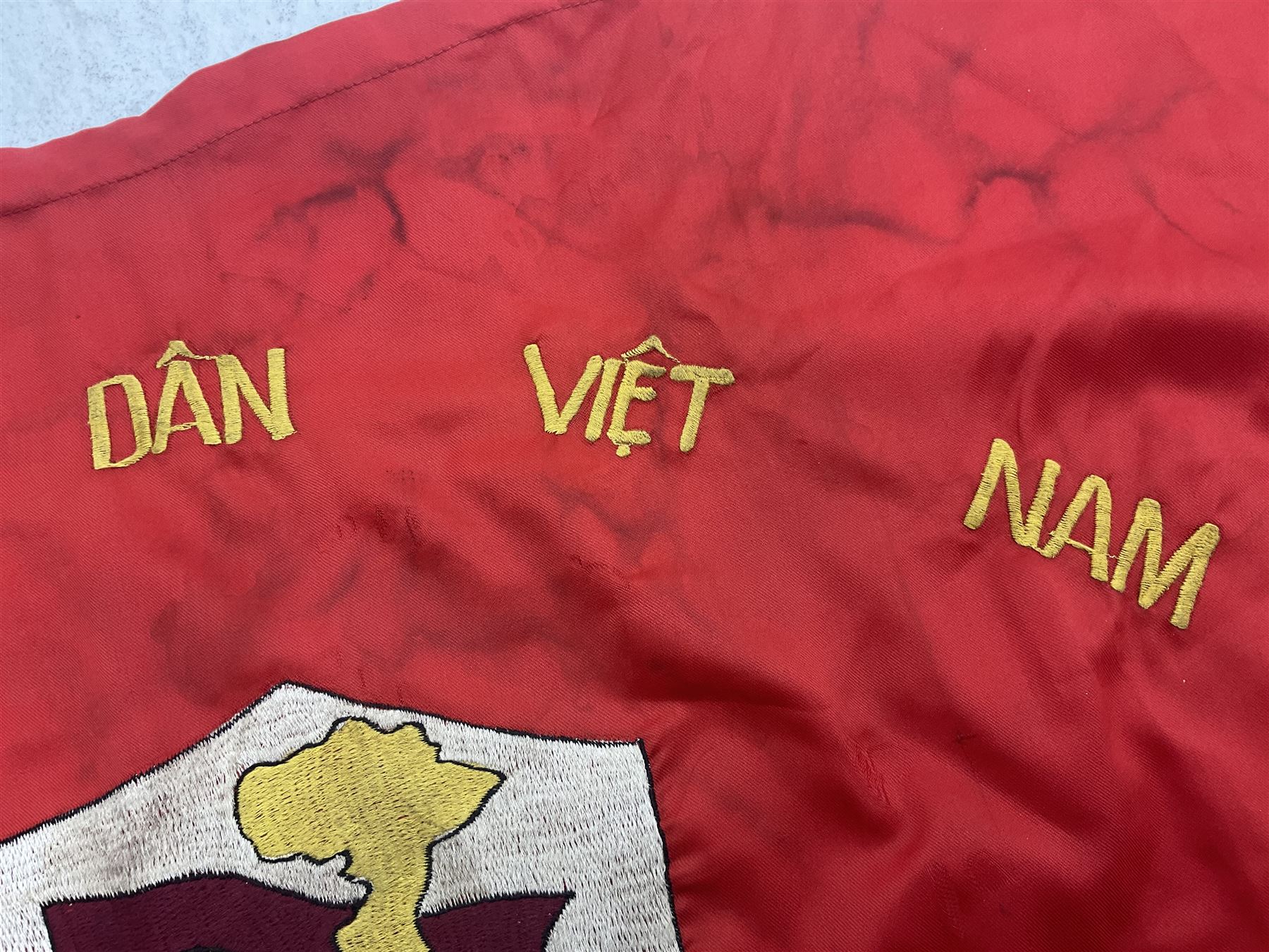 1960s North Vietnam banner embroidered in yellow thread on a red ground, roughly translates as 'Peoples Army of Viet Nam. Warriors of Viet Nam Determined To Keep The Country 1964' around a central military crest with the motto 'Warriors Keep The Country'; tassels to three sides 70 x 100cm