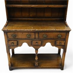 Georgian design oak dresser of small proportions, moulded cornice over open plate rack with two shelves and shaped apron, the base fitted with two drawers over three small drawers, brass drop handles, shaped apron, on square supports united by pot board