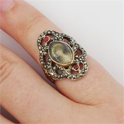 19th century gold and silver marcasite portrait ring, set with an oval miniature of a woman on ivory, under a glazed panel, with a marcasite and red stone set crossover surround, with pierced gold shoulders and reeded shank. This lot has been registered for sale under Section 10 of the APHA Ivory Act