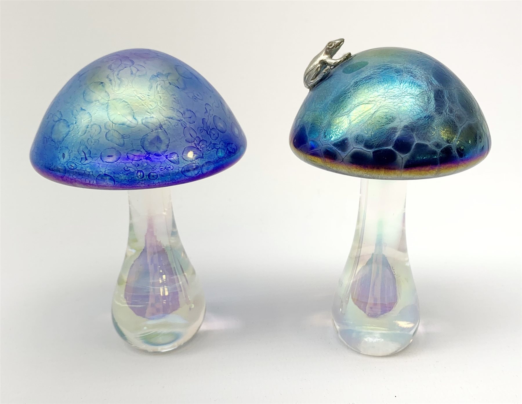 A John Ditchfield Glasform mushroom, in irridescent blue surmounted with a frog, H10.5cm, together with another similar John Ditchfield example. 