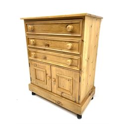 Solid pine chest, fitted with three long drawers and two small panelled cupboards, raised on castors 