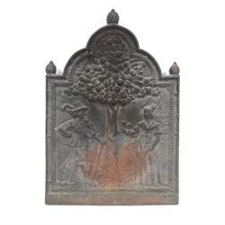 Cast iron fire back, depicting a couple under a tree with three acorn finials, H74cm