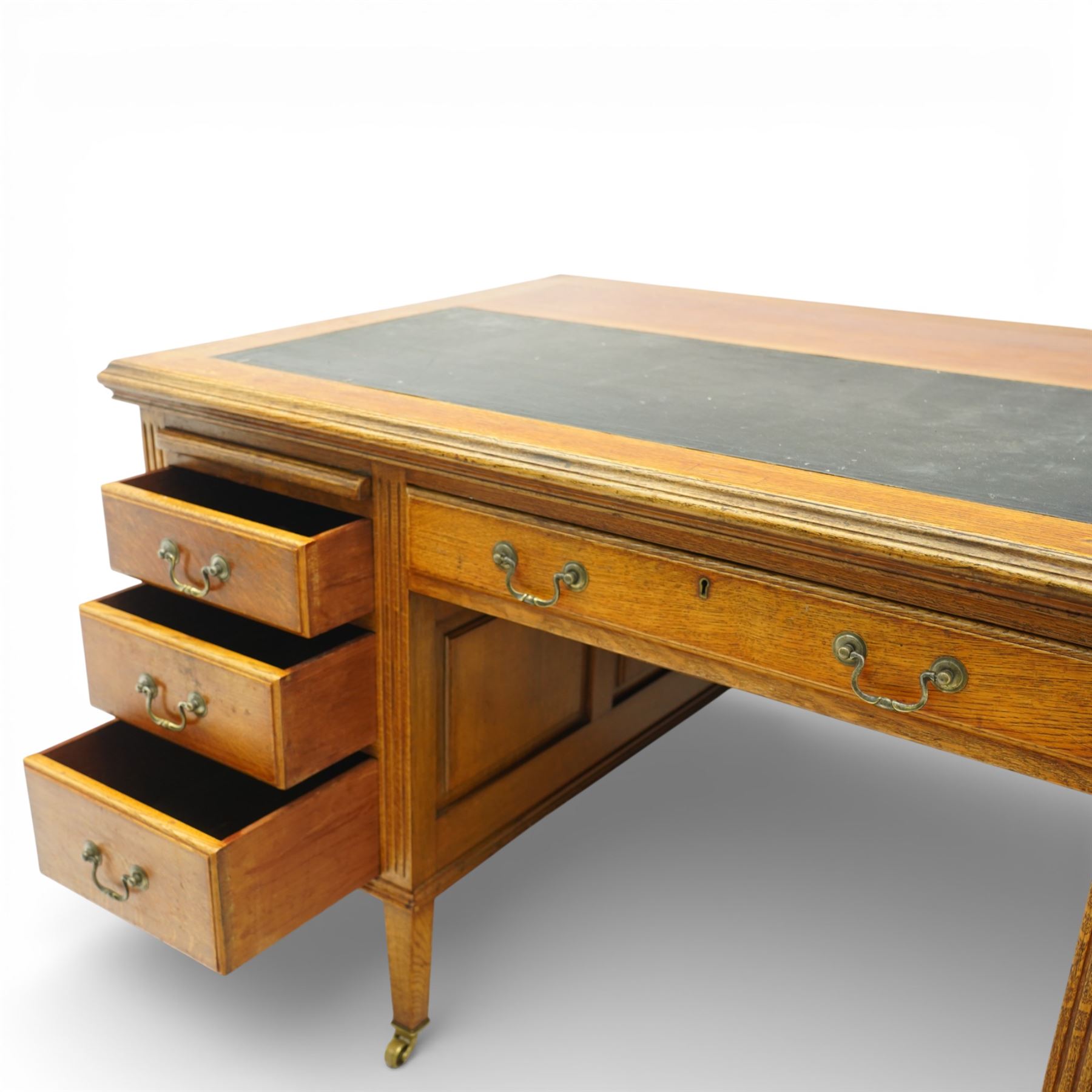 20th century oak kneehole desk, rectangular black leather inset top, above a single frieze drawer, flanked by two pedestals with slides and drawers, panelled sides and back 