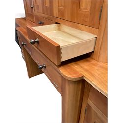 Large contemporary cherry wood break-front wall unit, the banded cornice over double cupboard with bifold doors and two drawers, flanked by four single cupboards, the base fitted with four drawers over four cupboards (W263cm, H216cm, D68cm); and a cherry wood cabinet, fitted with double cupboard over two short and two long drawers, with faux drawer facias (W81cm, H138cm, D66cm)