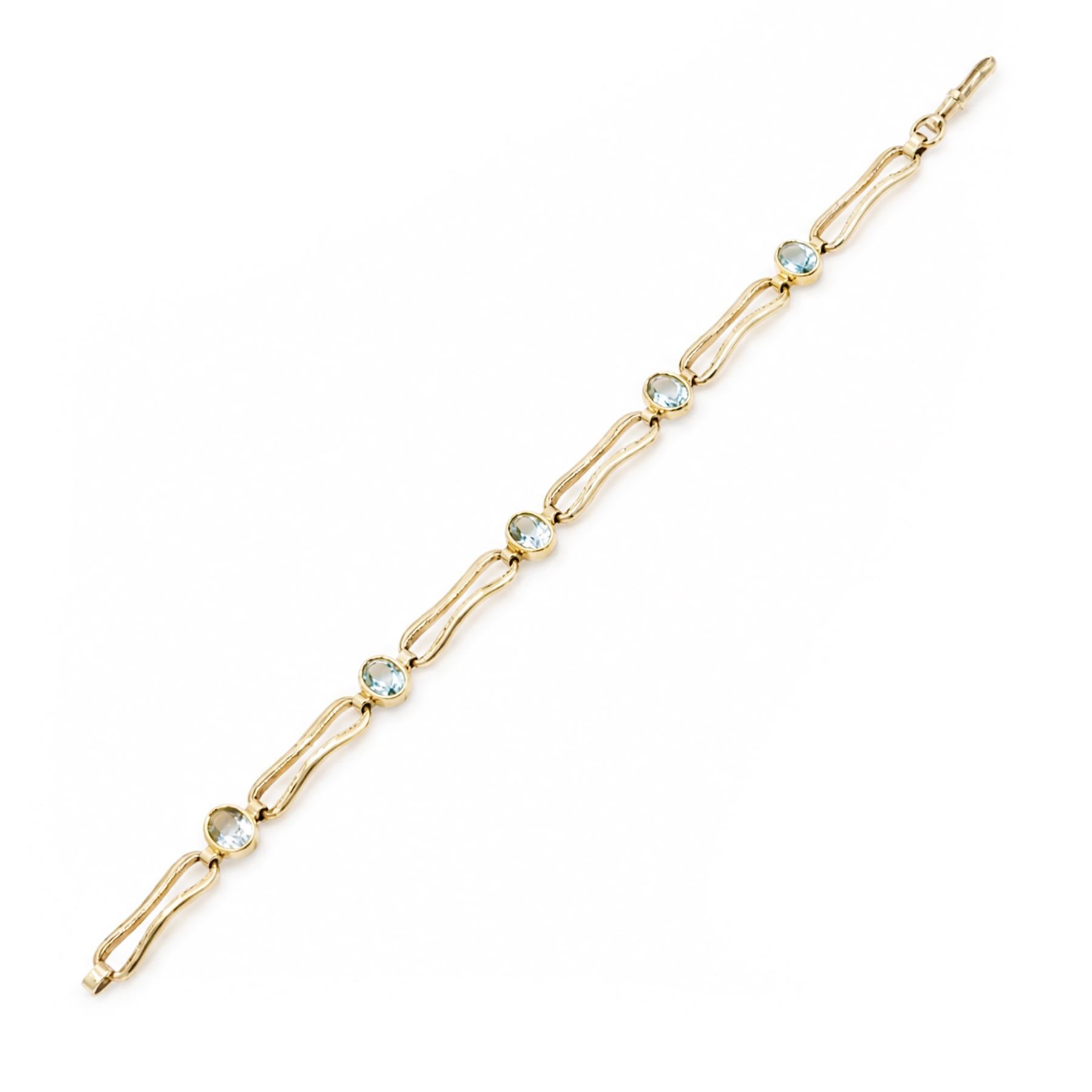 Gold blue topaz bracelet, bezel set with five oval cut topaz's, each spaced by fancy rectangular links, stamped 9ct